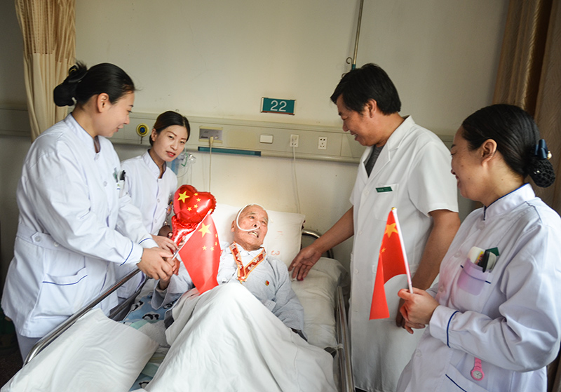 4峰峰总医院国庆节当日内三科病房里医护们为93岁的患者秦武平带上中共中央、国务院中央军委揭晓的国庆70周年岁念章并和他一起欢度国庆，，，，，秦爷爷曾加入过南征北战、孟良崮战争、淮海战争、抗美援朝是一名老武士、老革命 作者：肖建华(2).jpg